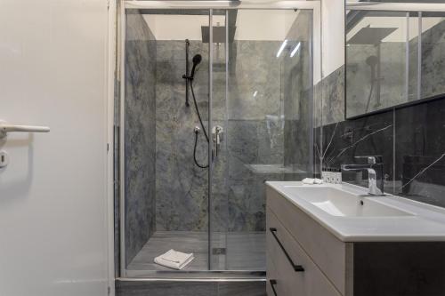 a bathroom with a glass shower with a sink and a shower at Delux Via Faenza in Florence