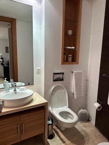 a bathroom with a white toilet and a sink at View green garden ligue arabe in Casablanca