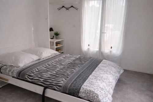 a white bedroom with a bed and a window at Mobil-home LOFT tout équipé Le Castellet les pins doux in Le Castellet