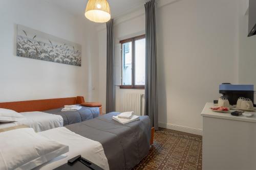 a room with two beds and a window at Delux Via Faenza in Florence