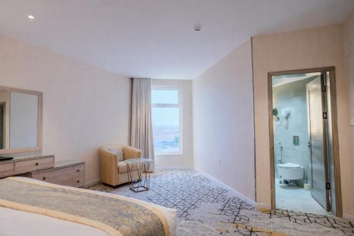 a bedroom with a bed and a bathroom with a shower at Grand Line in Tabuk