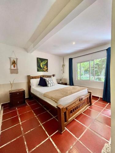 a bedroom with a bed and a large window at Manigua Tayrona Hostel in Santa Marta