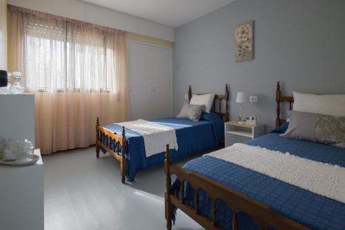 a bedroom with two beds and a window at Casa TINA in A Guarda