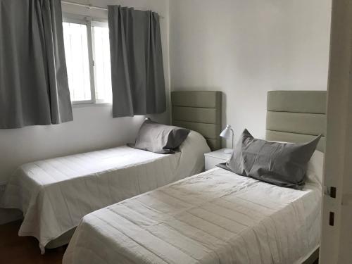 a bedroom with two beds and a window at Plaza Mitre, departamento 2 dormitorios in San Nicolás de los Arroyos