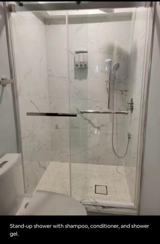 a shower with a glass door in a bathroom at Downtown and Inner Harbor Apartment in Baltimore