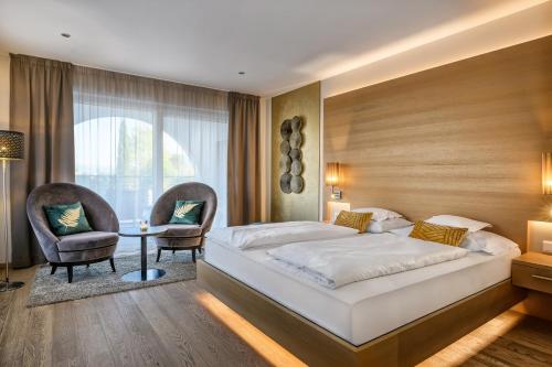 a bedroom with a bed and a table and chairs at FAYN garden retreat hotel in Lagundo