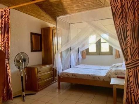 una camera da letto con letto a baldacchino con finestra di villa de standing a Nianing