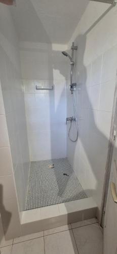 Un baño blanco con ducha con puerta de cristal. en villa de standing, en Nianing