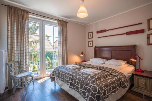 a bedroom with a bed and a large window at Willa Anna in Jastarnia
