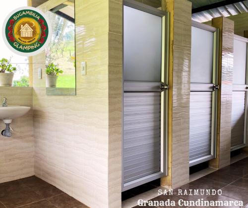 a bathroom with aluminium blinds on a window and a sink at Glamping Bugambilia in Subía