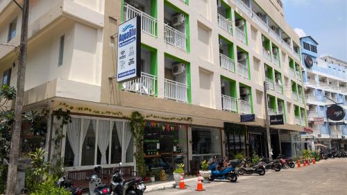 a large building with motorcycles parked in front of it at Issara Patong in Patong Beach