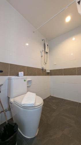 a bathroom with a white toilet and a phone at Issara Patong in Patong Beach