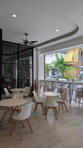 a restaurant with tables and chairs and a window at Issara Patong in Patong Beach
