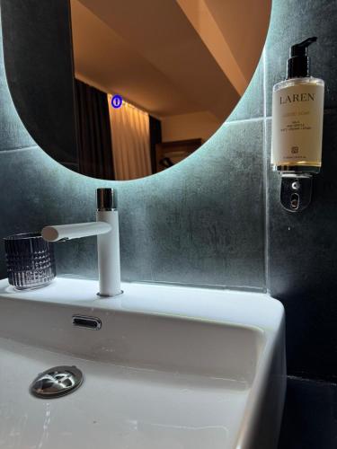 a bathroom sink with a mirror and a soap dispenser at XIX Boutique in Skopje