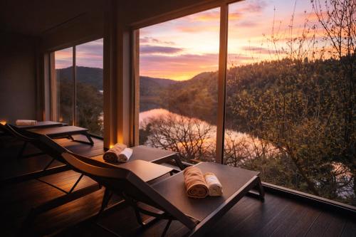 a room with two tables and a view of a lake at Hotel Rural Quinta da Conchada in Aguieira