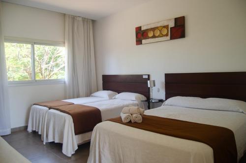 ein Hotelzimmer mit zwei Betten und einem Fenster in der Unterkunft Hotel Oaky in Posadas