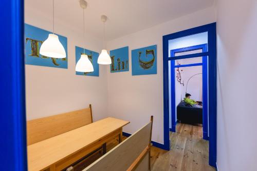 a room with a wooden bench and a blue door at Help Yourself Hostels - Parede in Parede