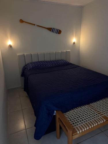a bedroom with a bed and a baseball bat on the wall at Mini Casa Privativa -Praia do Tombo in Guarujá