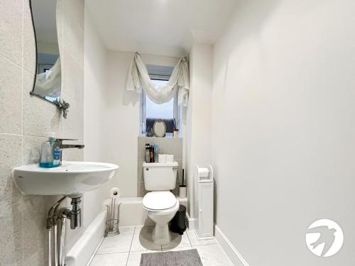a bathroom with a white toilet and a sink at 6 Bed Longstay & Shortstay property with Wifi & parking sleeps 14 in Chatham