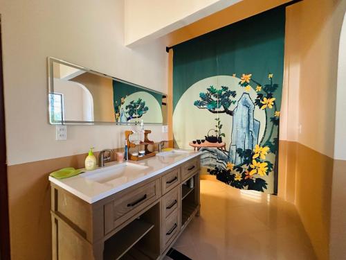 a bathroom with a sink and a large painting on the wall at Rustic Homeaway - Stay with the local in Phong Ðiền