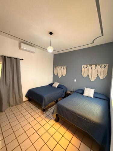 a bedroom with two beds and a window at Casa Valentía in Tequila