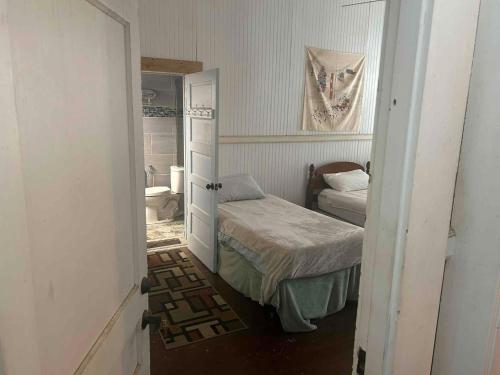 a small bedroom with a bed and a bathroom at Hale Naalehu LLC Bed and Breakfast in Naalehu