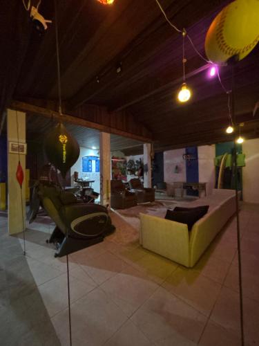 a living room with a couch and a chair at Stay Guesthouse Boutique in Guarujá