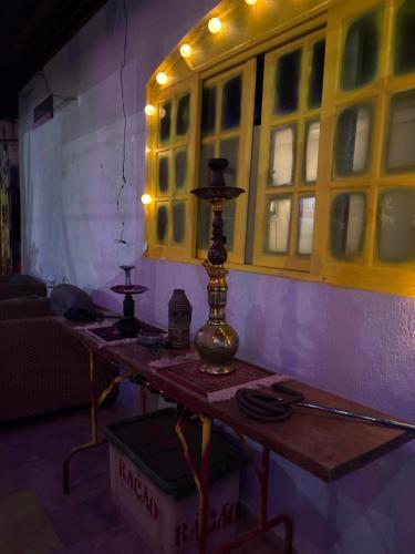 a table with a lamp on it in a room at Stay Guesthouse Boutique in Guarujá
