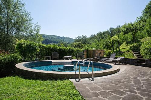 a small pool with a slide in a yard at Il Nido - Private villa with pool and jacuzzi in Castelnuovo di Garfagnana
