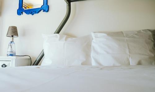 a bed with white sheets and pillows on it at Help Yourself Hostels - Restelo in Lisbon