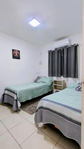 a bedroom with two beds and a window at Apartamento paid'egua completo em Belém in Belém