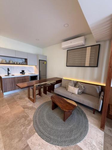 a living room with a couch and a table at Beach Studio Playa del Carmen MX in Playa del Carmen