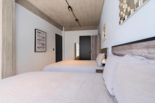 two beds in a bedroom with white walls at Zielo Rentals Palma ,Private balcony, Rooftop Walk to Zocalo in Mexico City