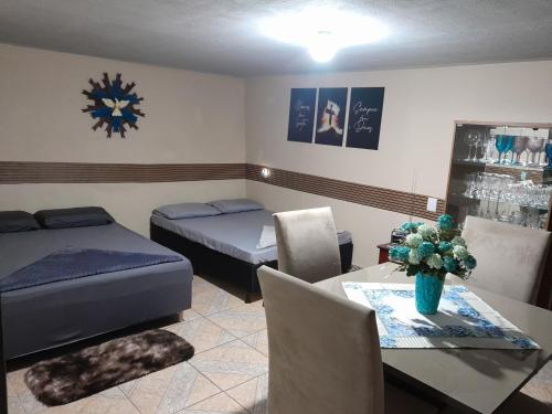 a room with two beds and a table with a dining room at Recanto Romig in Pomerode