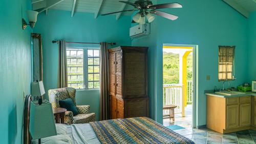 a bedroom with blue walls and a bed with a ceiling fan at Lamblion Holiday Apartment in Freemans