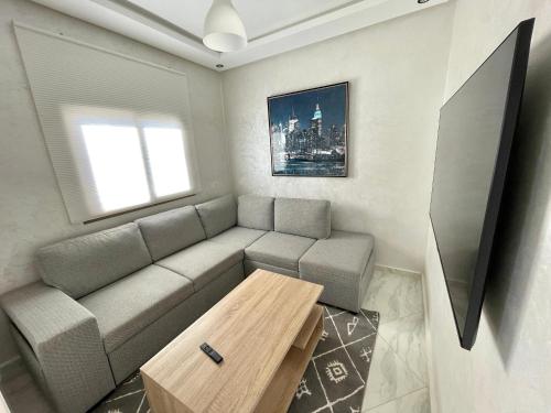 a living room with a couch and a table at A2 Luxe Moderne et Confort, 7 min du Stade Moulay Abdellah in Temara