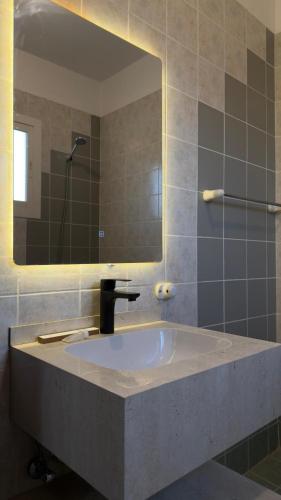 a bathroom with a sink and a mirror at فيلا بيتا خصوصيه في الشاطئ والمسبح in Durat Alarous