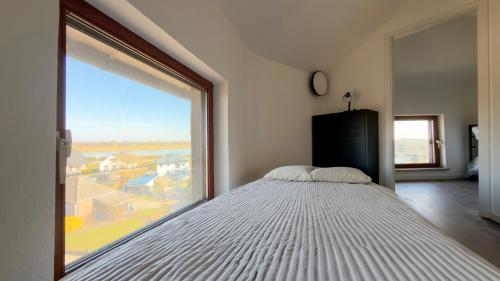 a bed in a room with a large window at Einzigartig übernachten im Wasserturm an der Elbe in Stelle