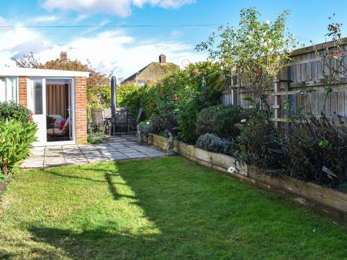 a backyard with a yard with grass and a fence at Why Not in Canterbury