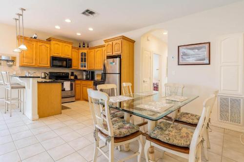 a kitchen and dining room with a glass table and chairs at Beach & Palms condo condo in South Padre Island