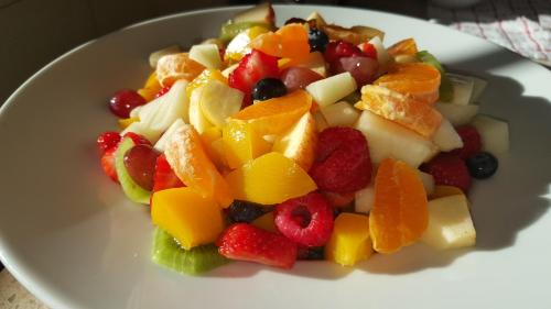 a white plate of fruit salad on a table at Bod Gwynedd Bed and Breakfast in Betws-y-coed