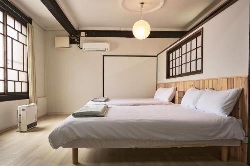 two beds in a room with two windows at 甘口派room in Obanazawa