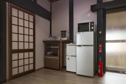 a kitchen with a refrigerator and a microwave on top of it at 甘口派room in Obanazawa