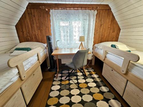 a bedroom with two beds and a desk and a table at DOMEK NAD WISŁĄ in Kazimierz Dolny
