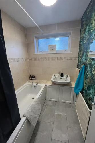 a bathroom with a tub and a sink at Cosy Home Contractors, Relocations, Coffee Machine in Beoley