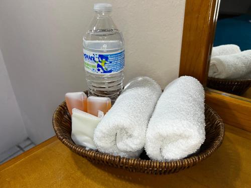 a basket of towels and a bottle of water at hotel Rarámuri in Creel