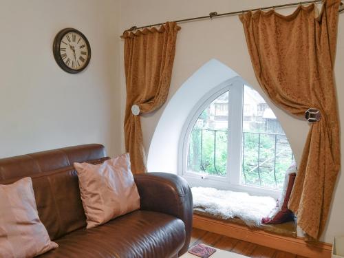 a living room with a leather couch and a window at 5 Church Square in Rigg