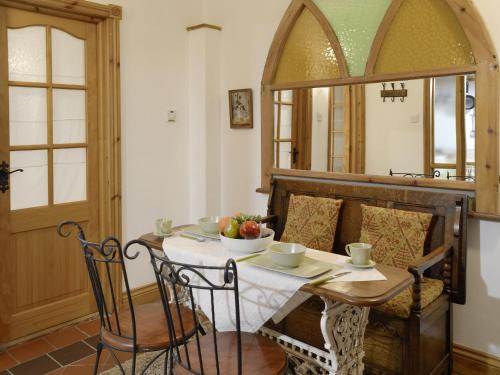 a dining room with a table and chairs and a mirror at 5 Church Square in Rigg