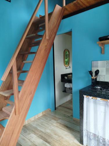 a staircase in a house with blue walls and wood at Chalé Studio Haven, microcasa com Mezanino e banheira in Lumiar