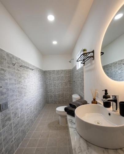 a bathroom with a sink and a toilet and a mirror at Hospedaje Suites Aeropuerto Villahermosa in Villahermosa